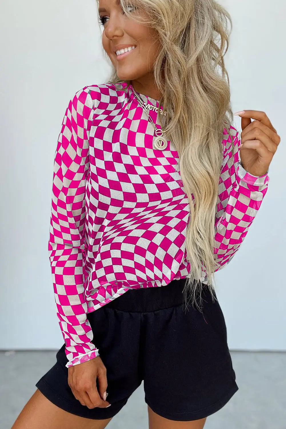 Pink and white checkered polyester women's top with stretchy fabric and short sleeves.