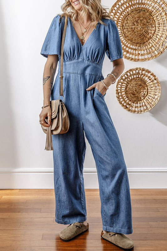 Ashleigh – Blauer, lockerer Jeans-Jumpsuit mit V-Ausschnitt und gesmoktem Rücken